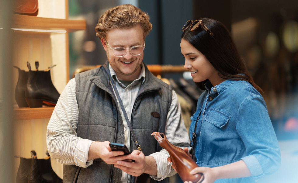Un membre de l’équipe de vente utilise l’iPhone en magasin pour aider la clientèle.
