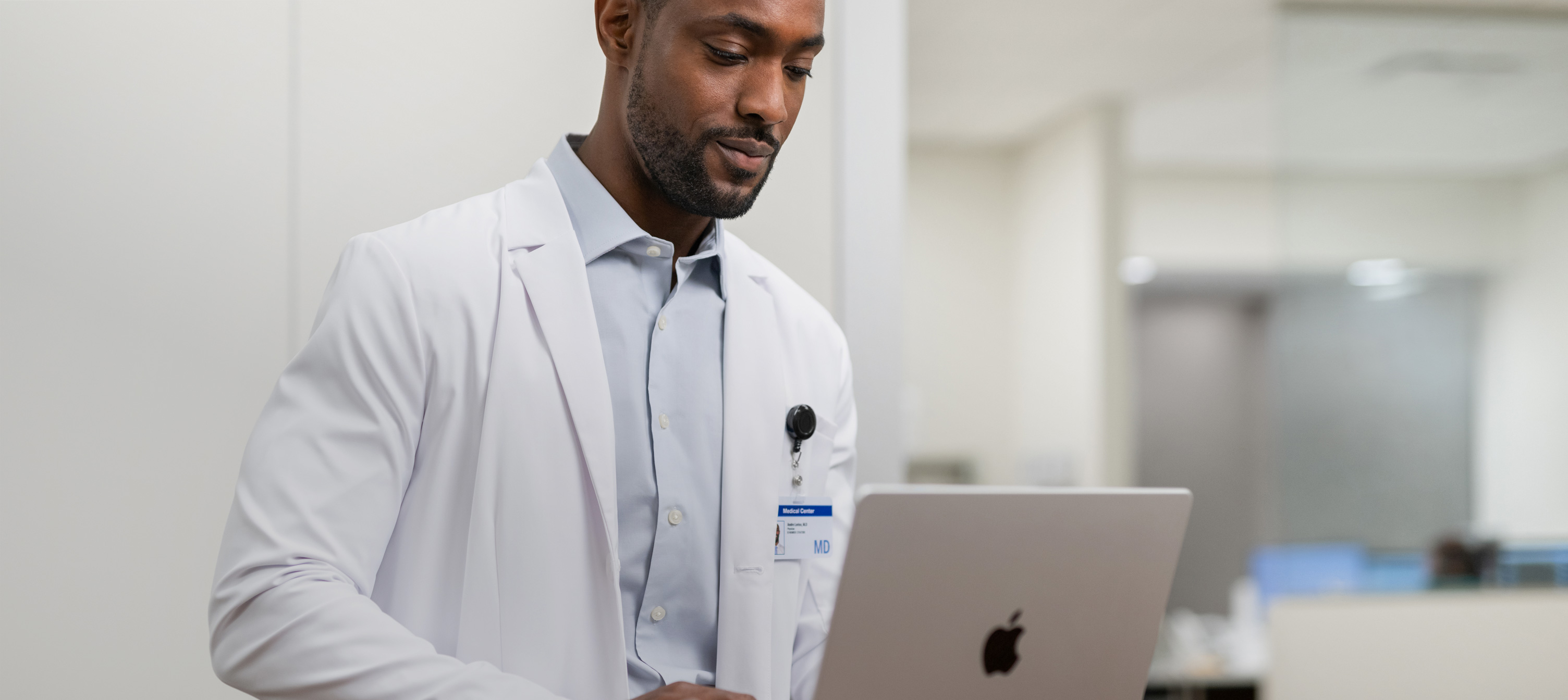 Un medico che lavora sul suo MacBook Pro in ospedale.