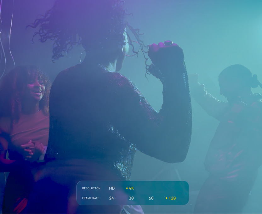 Näytöllä ihmisiä, jotka tanssivat hämärässä valaistuksessa, kuva esittelee 4K-tasoista 120 fps Dolby Vision ‑kuvausta